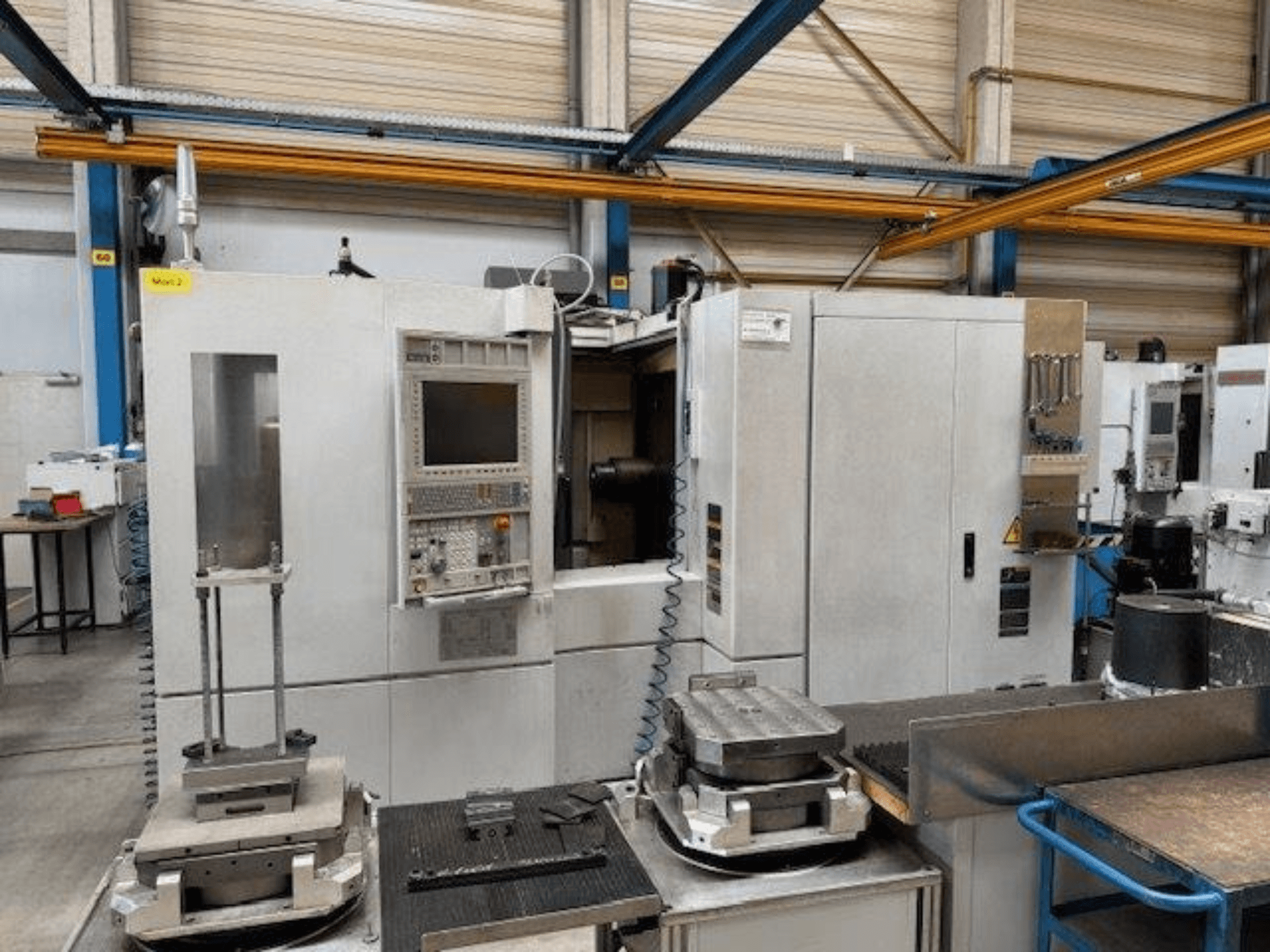 MORI SEIKI NH4000 DCG front view of a horizontal machining centre with control panel and workpieces on the table.