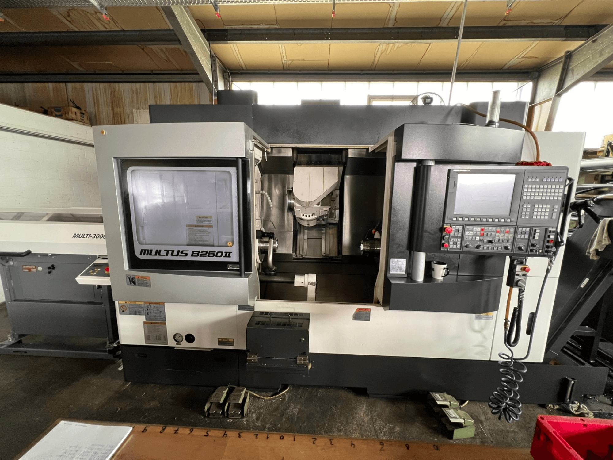 Okuma Multus B250II MW turn-mill centre, front view, showcasing control panel and machining area details.