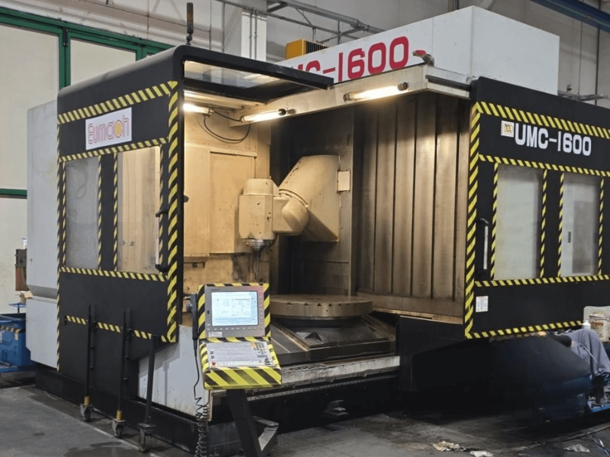 Eumach UMC-1600 vertical machining centre, front view showing controls and machining area with safety stripes.