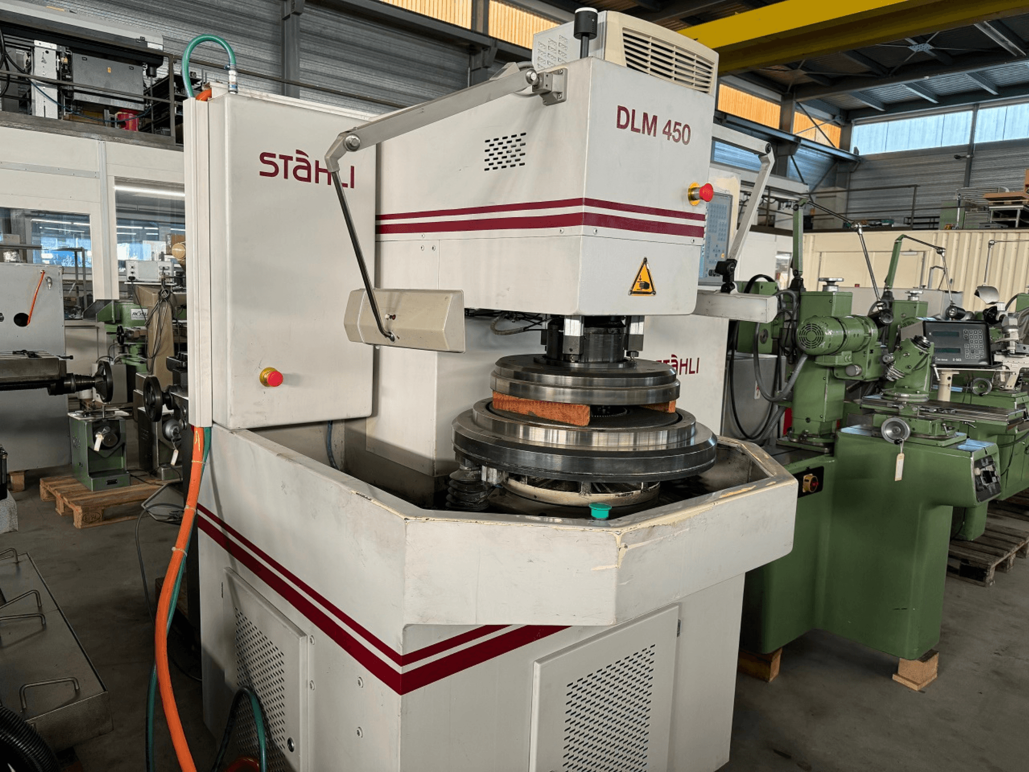 STAEHLI DLM 450 surface grinding machine, front view with grinding wheel and control panel, in an industrial setting.