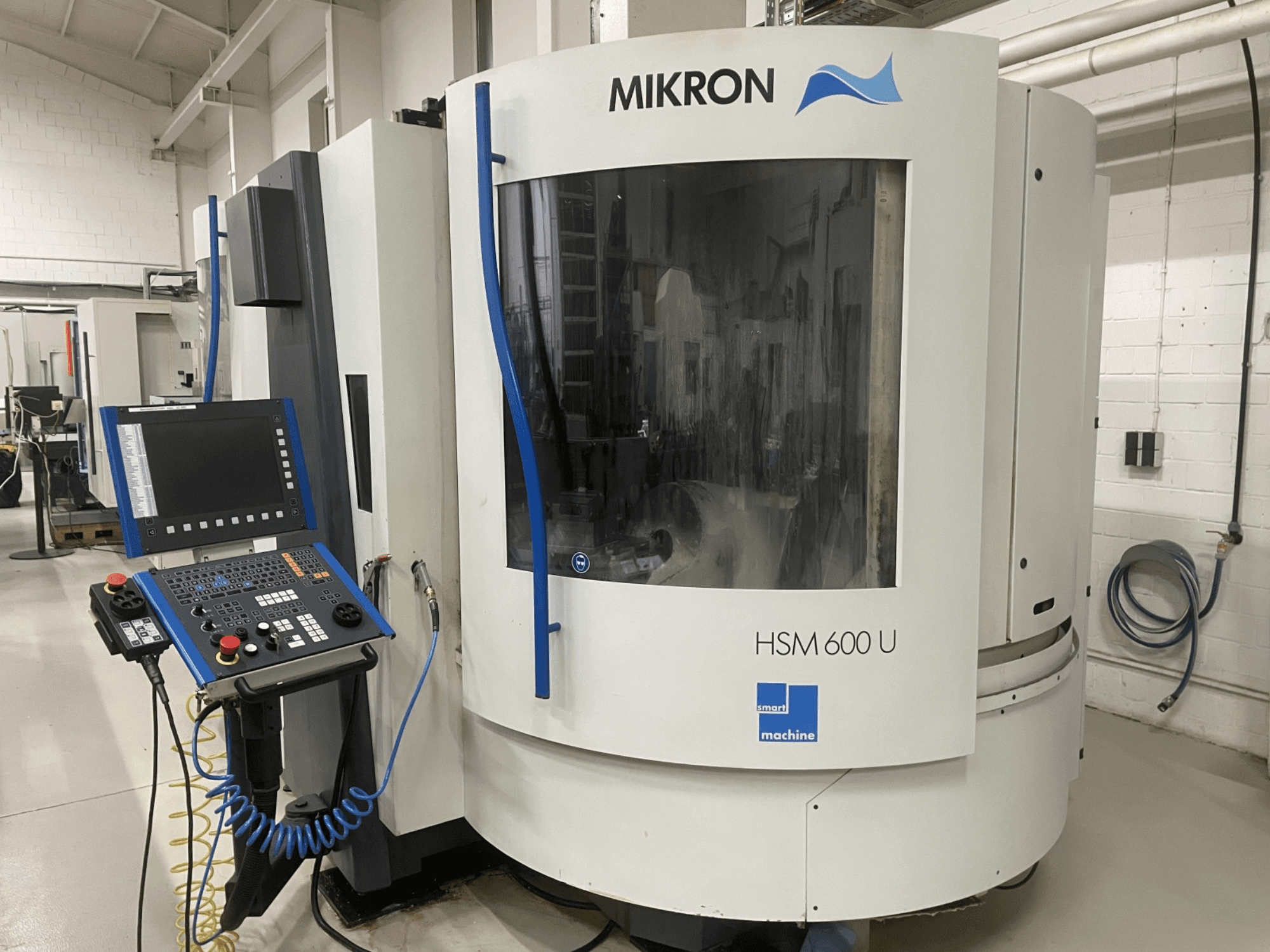 MIKRON HSM600U vertical machining center shown from the front, featuring an operational control panel and large viewing window.