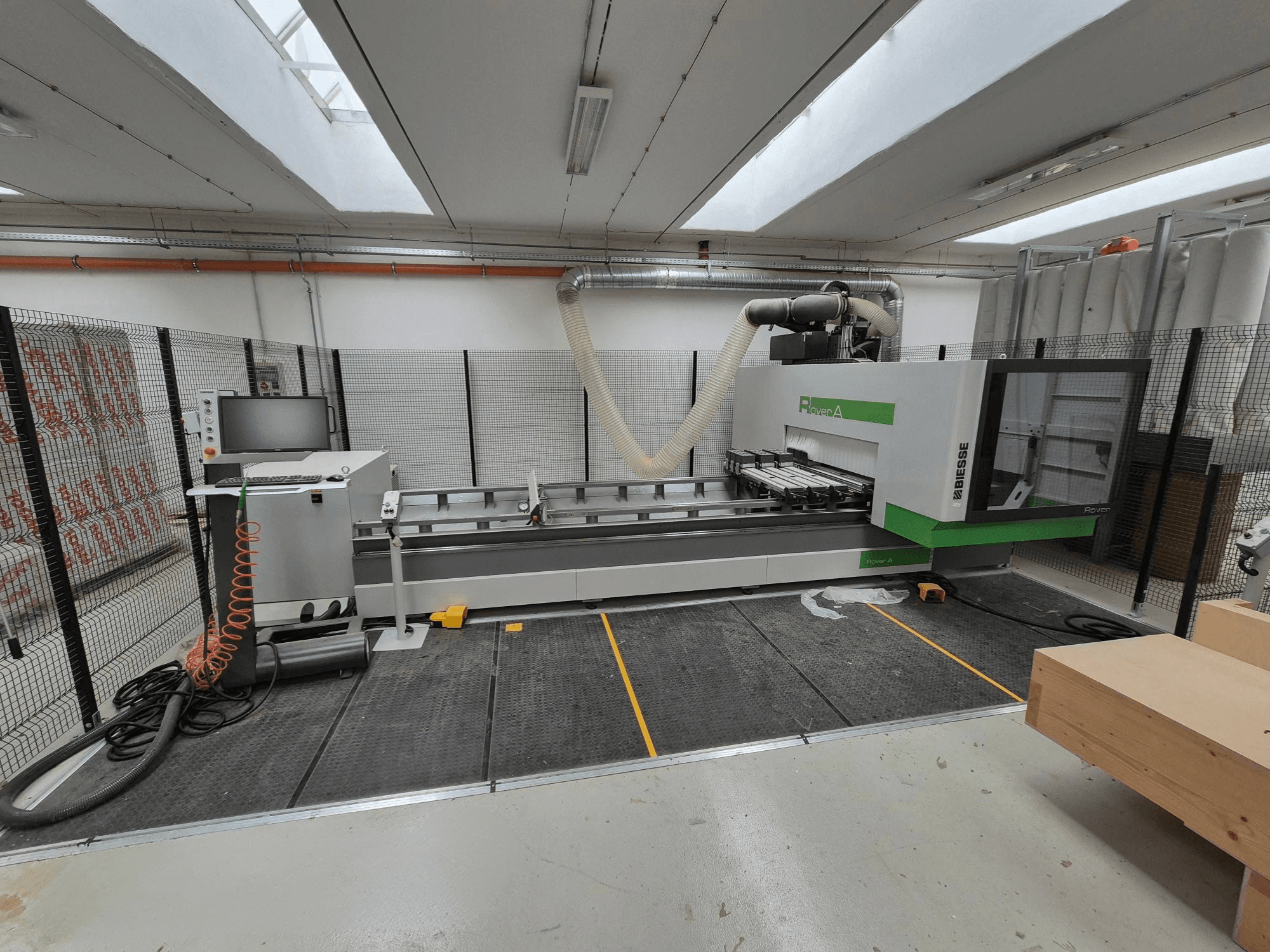 Biesse Rover A CNC machine in a workshop, front view. Features a control panel, vacuum system, and work surface.