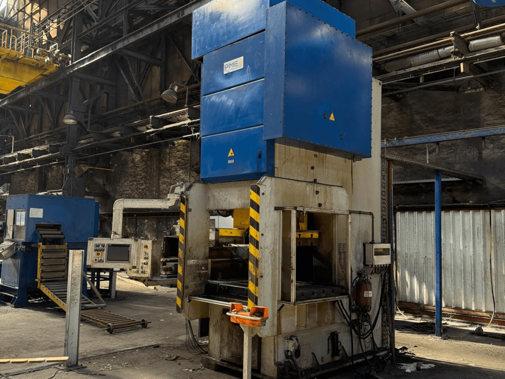 PME PE 400-1700 C mechanical stamping press, front view, showing blue top and yellow-striped base in a factory setting.