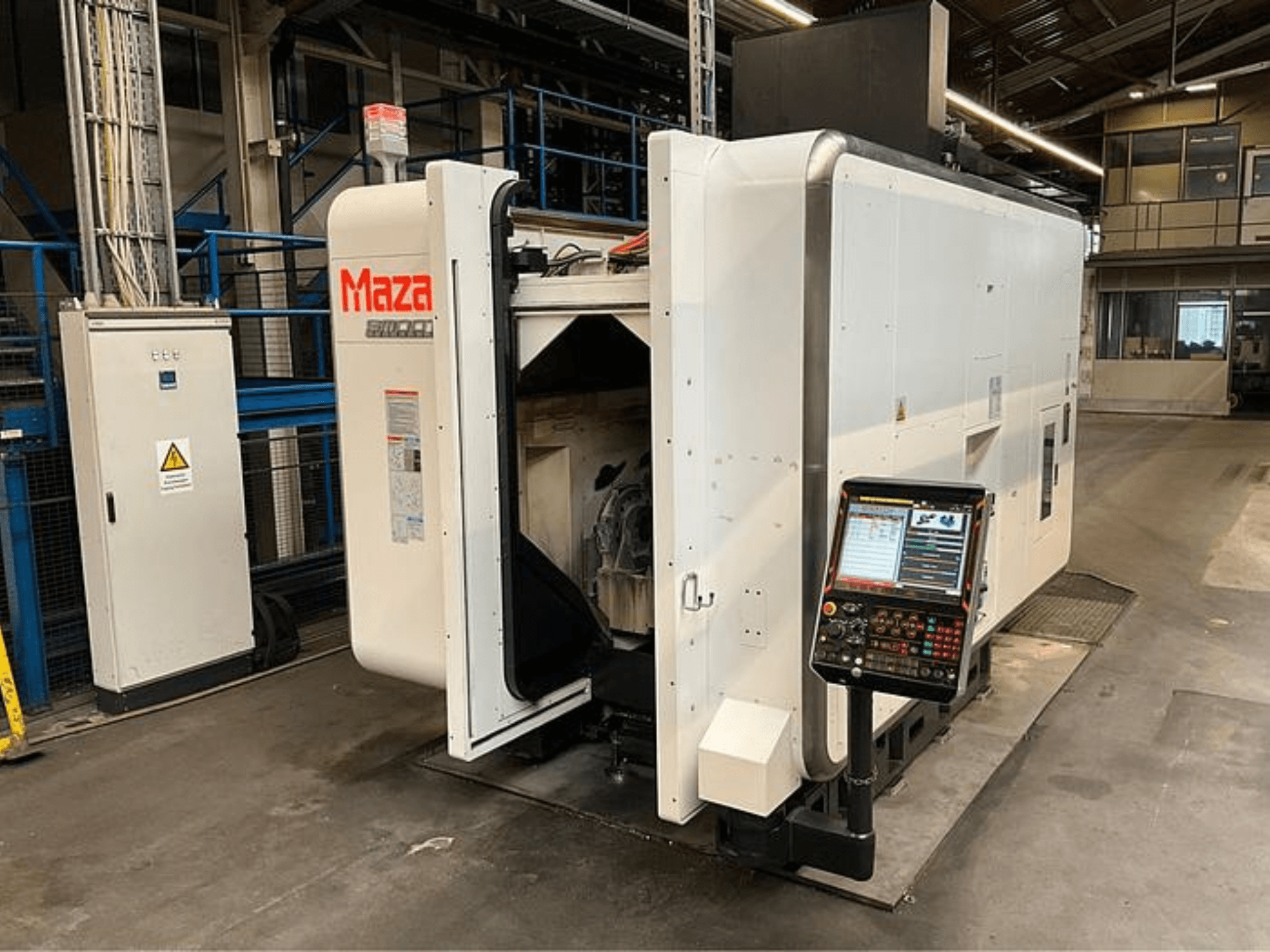Maza CNC machine shown from a front view, featuring a control panel, industrial design, and visible machinery components.