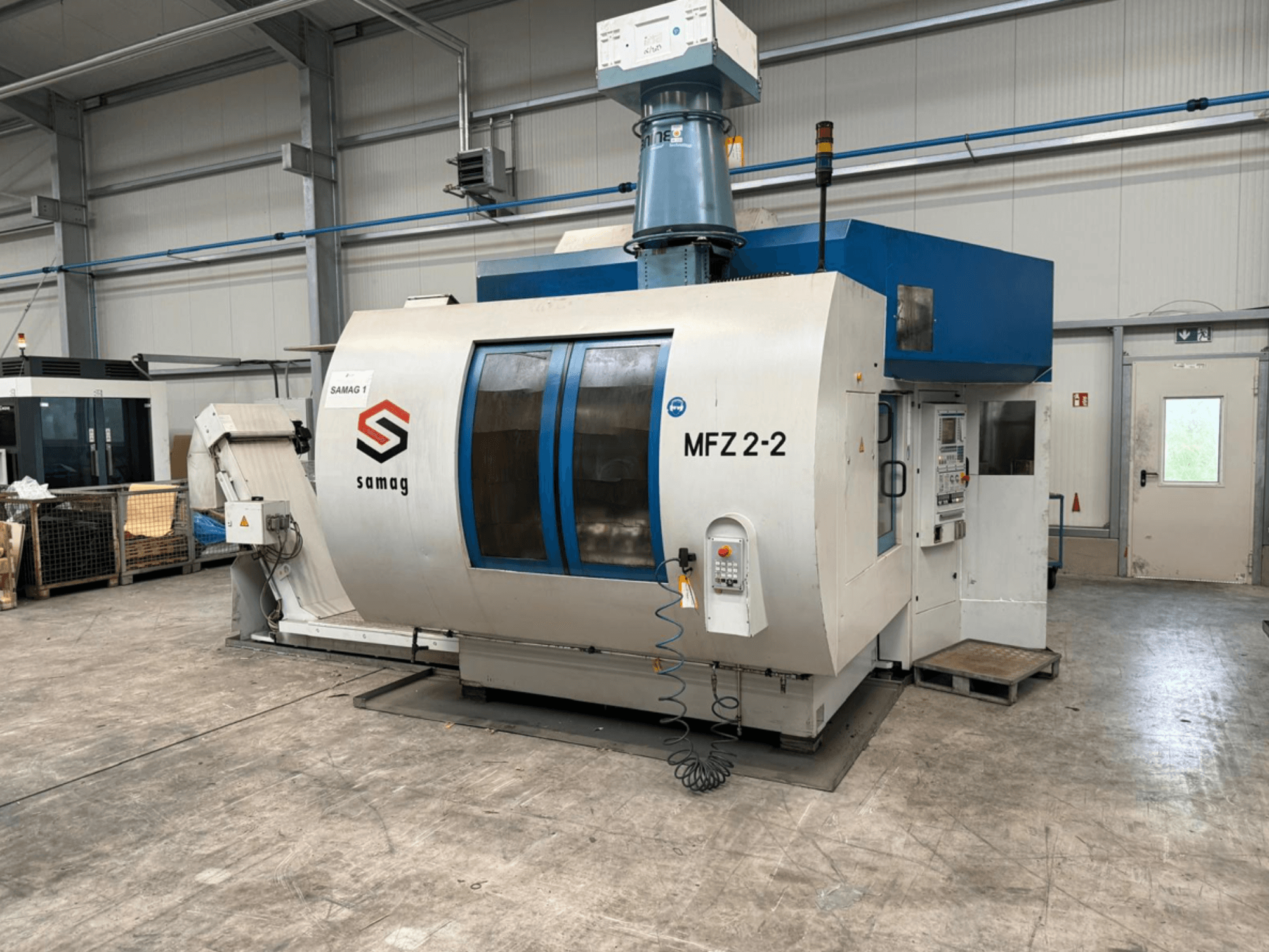 Samag MFZ 2-2 machine tool, front view, showing control panel and blue top, with safety features in an industrial setting.