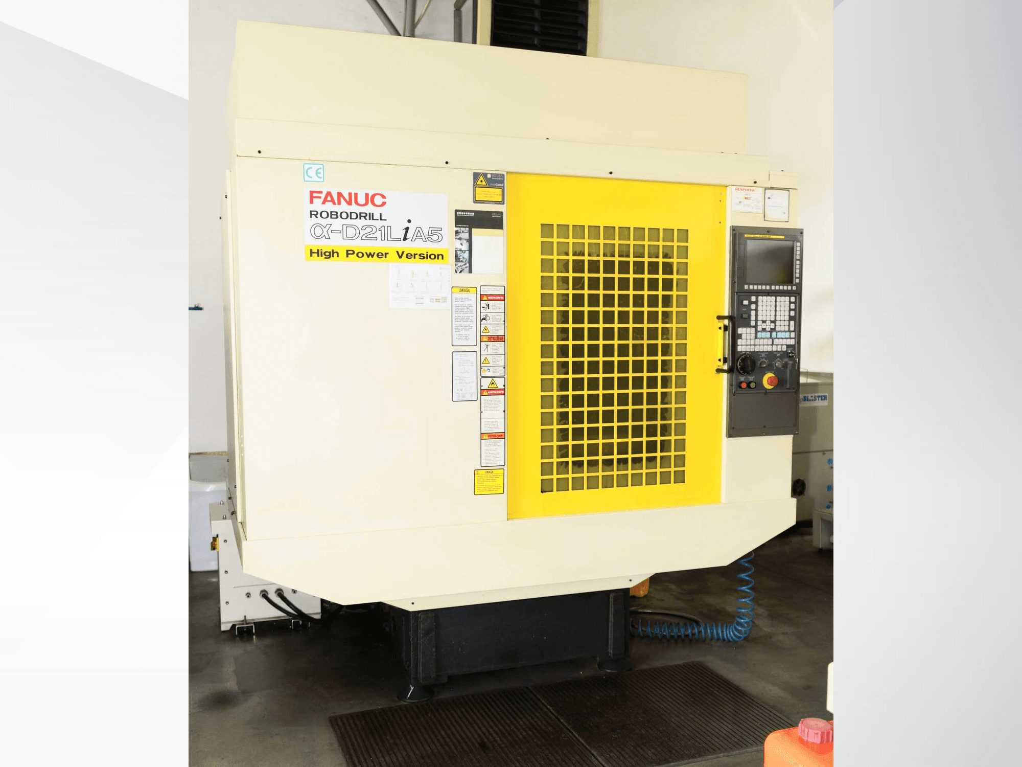 FANUC ROBODRILL α-D21LiA5 vertical machining center, front view with yellow safety grille and control panel details.
