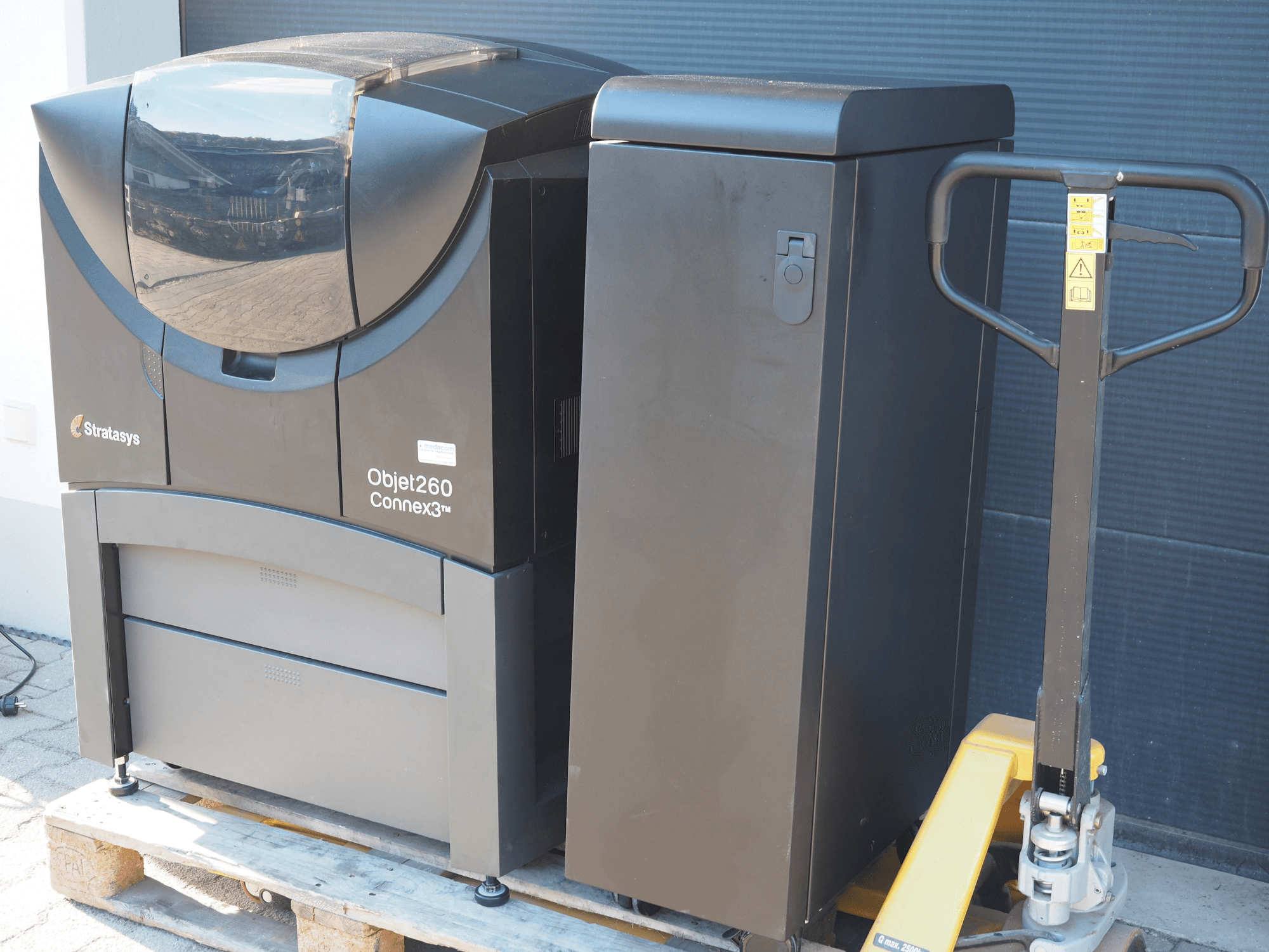 Stratasys Objet260 Connex3 plastic 3D printer, side view, features compact design with control panel and connected material bin.