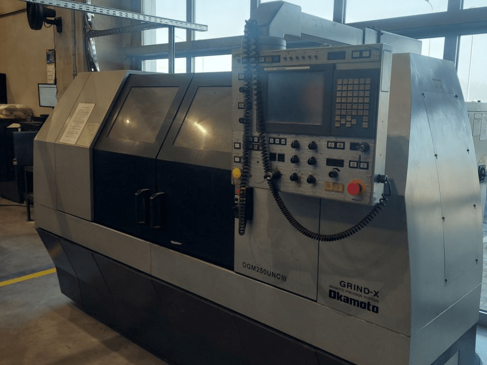Cylindrical grinding machine OKAMOTO OGM 250 UNC III, front view, showcasing control panel and dual window design.