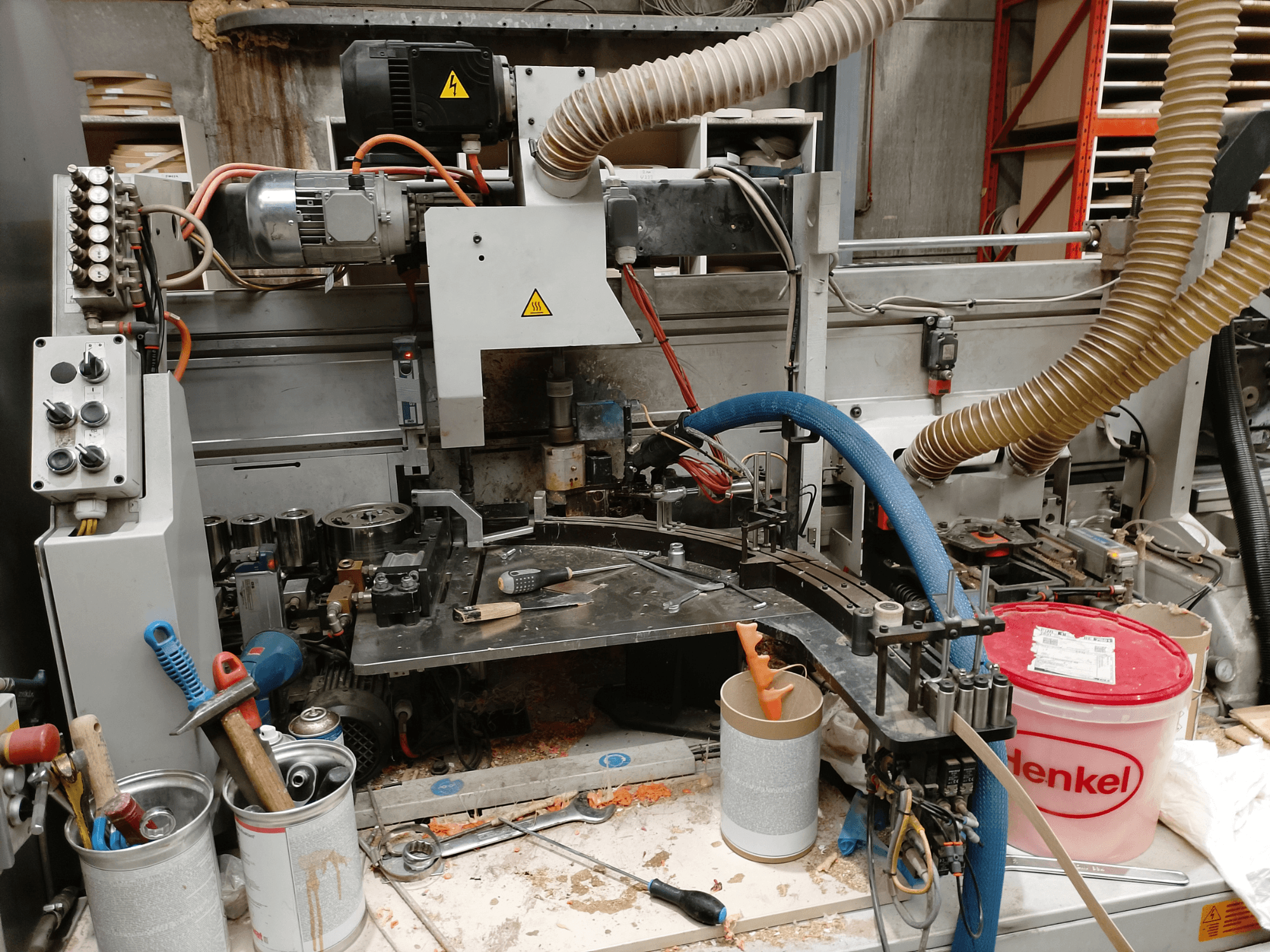 BIESSE Edge Stram B1 edgebander in front view, showcasing machinery, hoses, and work tools amid wood shavings.