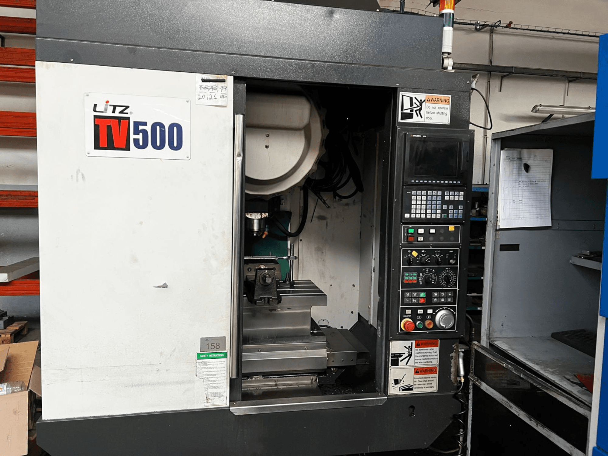 Litz TV500 vertical machining centre front view, featuring control panel, spindle, and work area inside the machine.