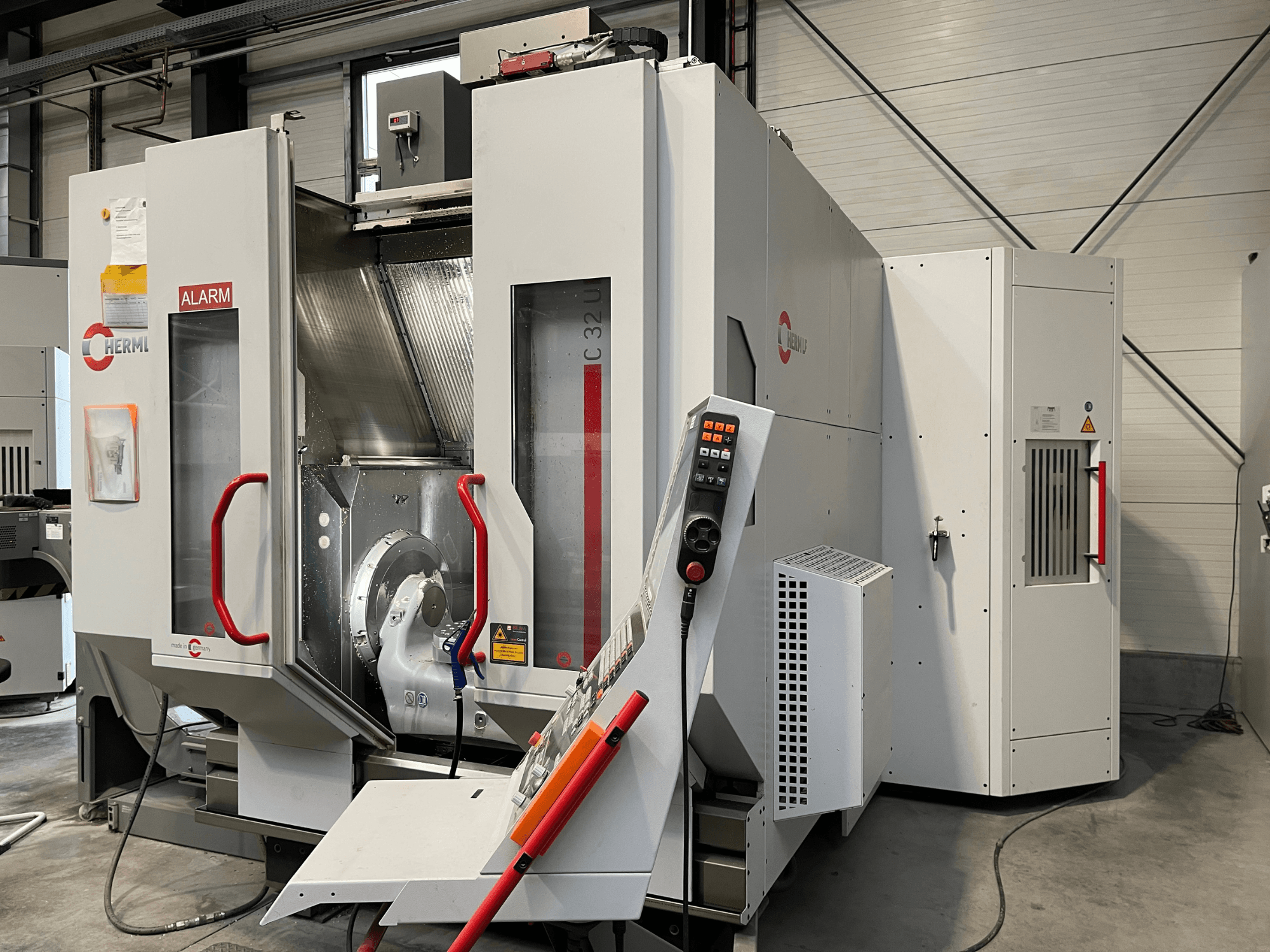 HERMLE C 32 U Universal Machining Centre in front view, featuring a control panel and red safety handles.