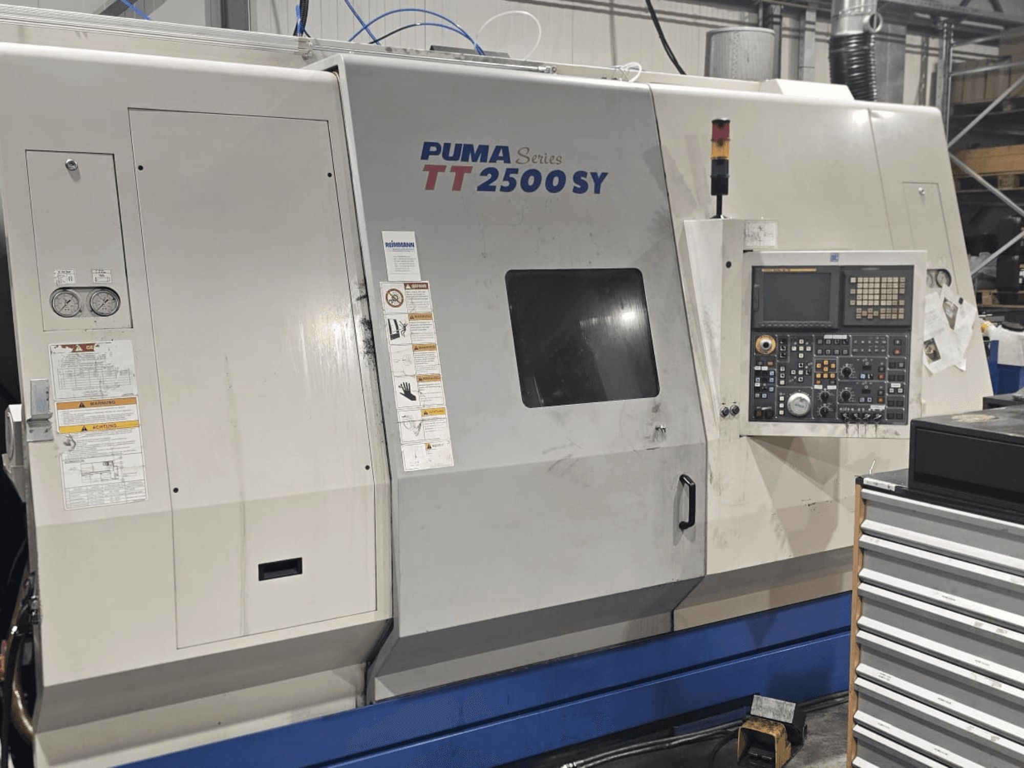 PUMA Series TT 2500 SY CNC lathe, front view; control panel with dials and buttons, gauges, and operation labels visible.