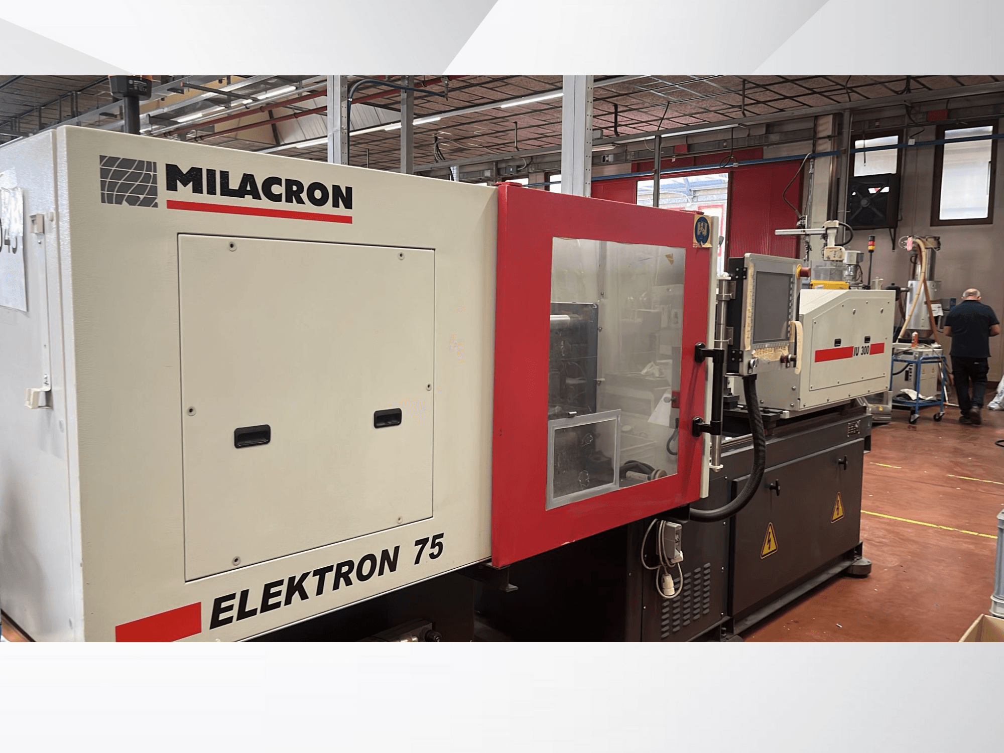 Milacron Elektron 75 injection molding machine in a workshop setting, side view showcasing its control panel and mechanical parts.