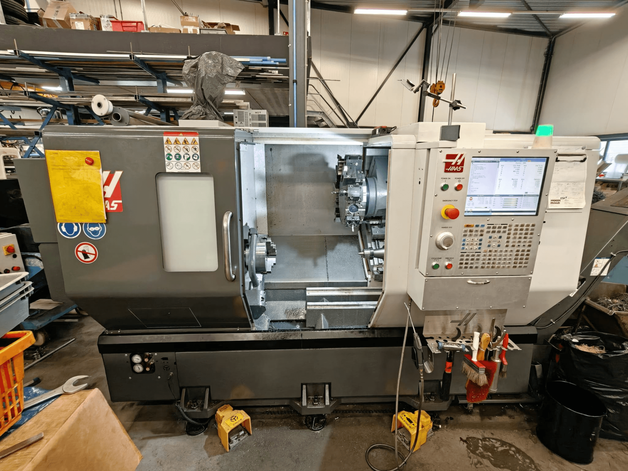 HAAS ST-25Y horizontal turning machine, front view, showing control panel, tool storage, and operational setup in workshop.
