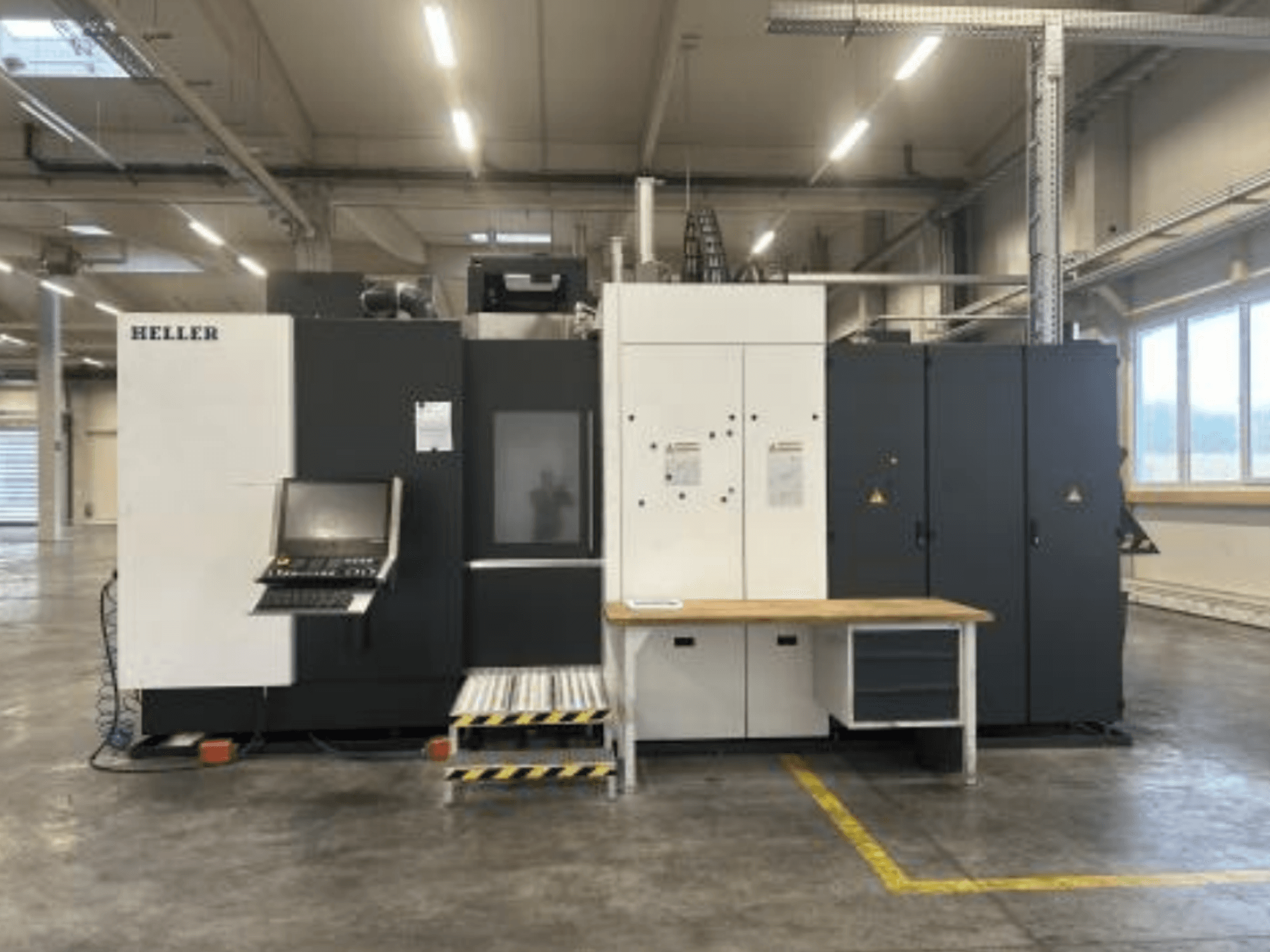 Horizontal Machining Centre HELLER H5000, front view showcasing control panel, tool storage, and workspace table.
