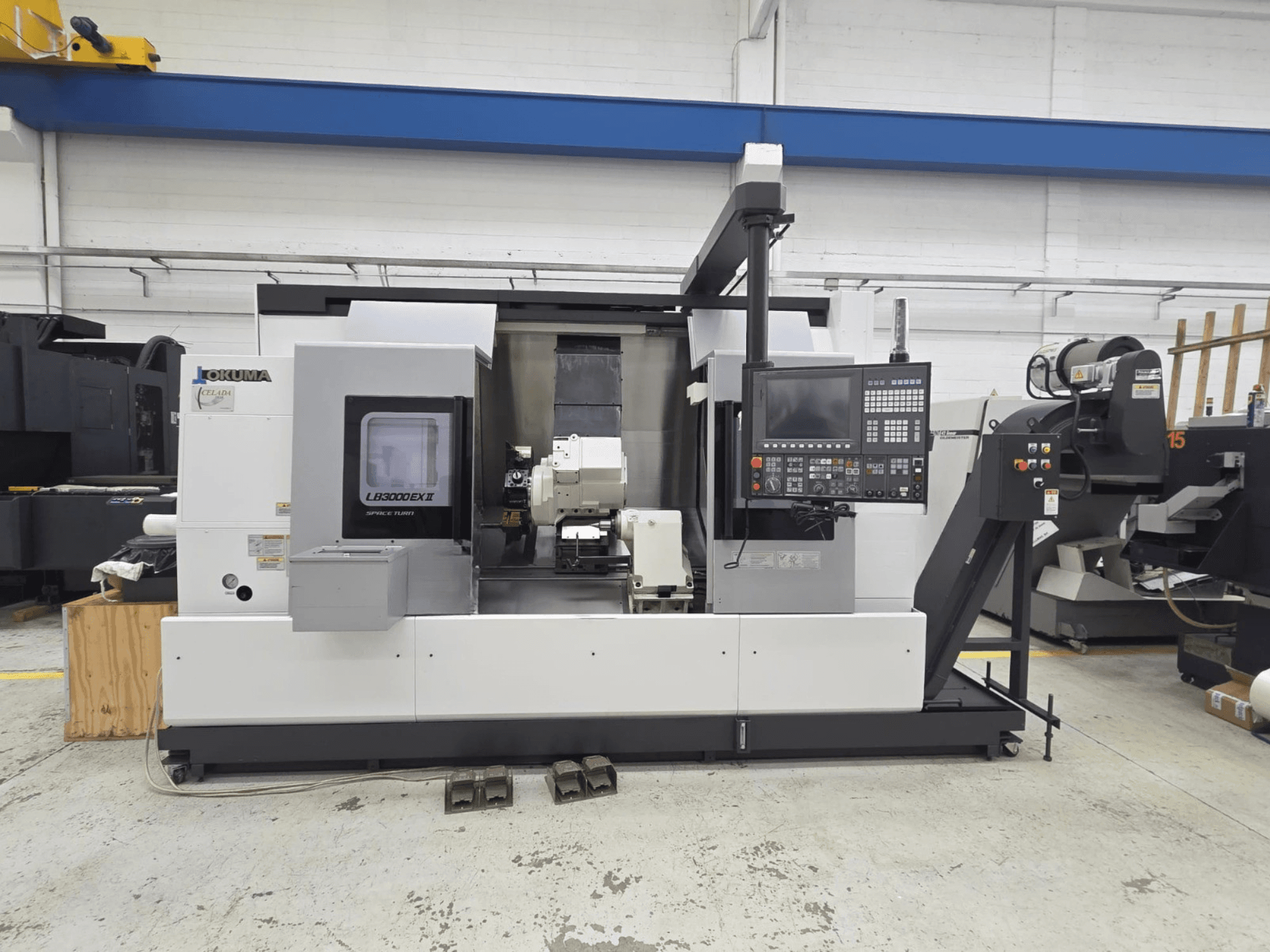 Okuma LB 3000 EXII horizontal turning machine shown front view, featuring a control panel and tool holder.