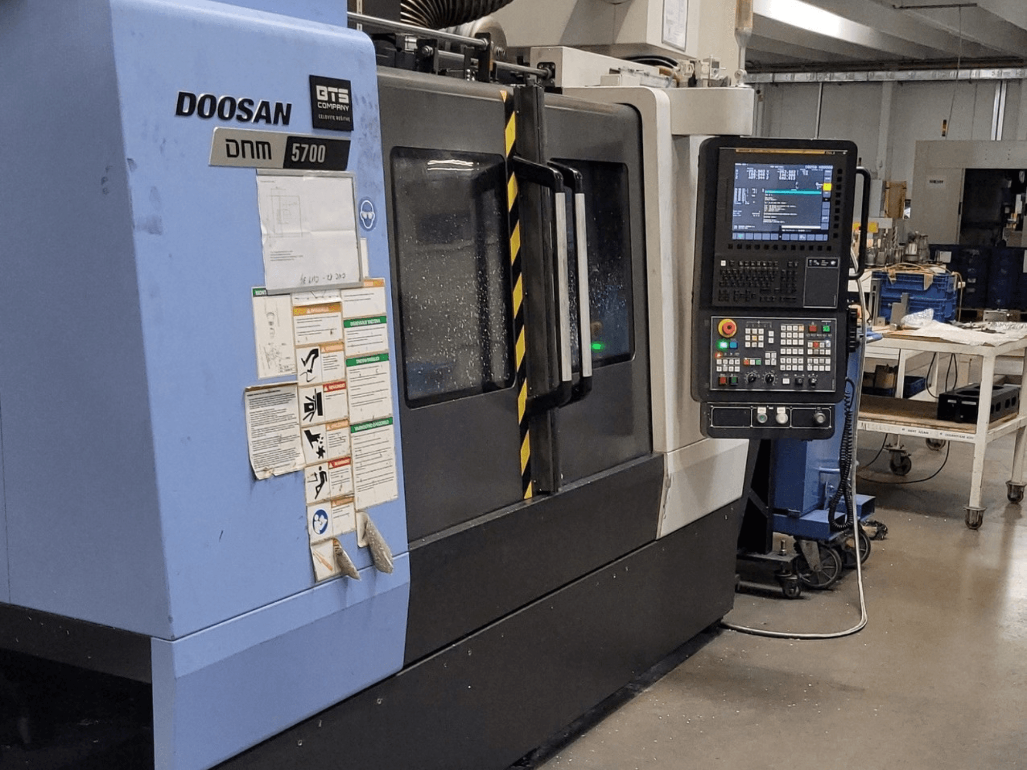 DOOSAN DNM 5700 vertical machining center, front view, showcasing control panel and operational controls.